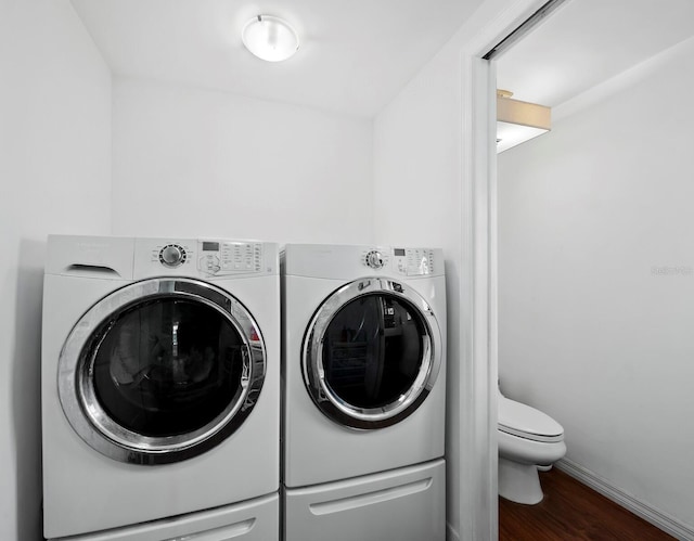 laundry room with hardwood / wood-style flooring and washing machine and clothes dryer