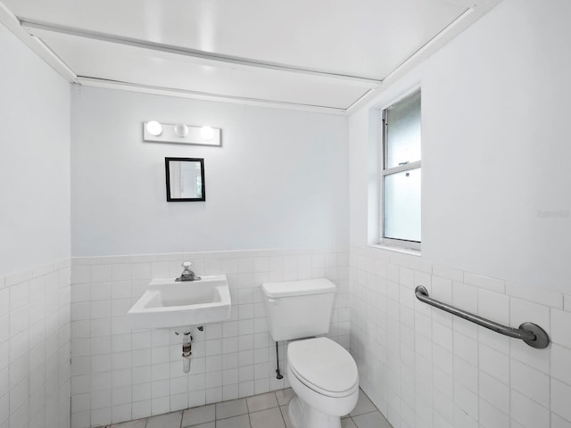 bathroom featuring tile patterned floors, sink, toilet, and tile walls