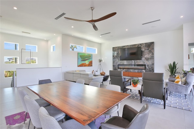 tiled dining room featuring ceiling fan, a premium fireplace, visible vents, and recessed lighting