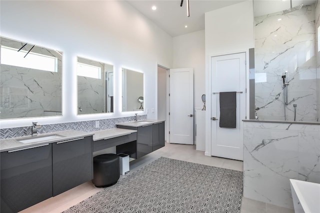 bathroom with a high ceiling, a marble finish shower, vanity, and recessed lighting