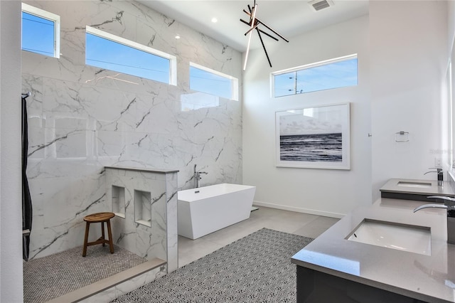 bathroom with double vanity, a freestanding tub, a sink, and a marble finish shower