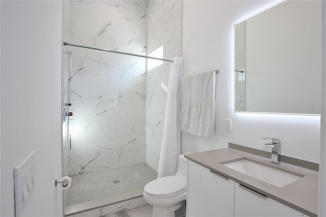 full bathroom featuring toilet, marble finish floor, a marble finish shower, and vanity