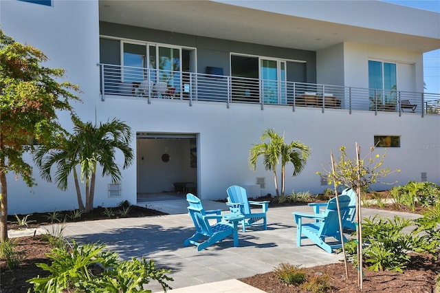 rear view of house featuring stucco siding and a patio