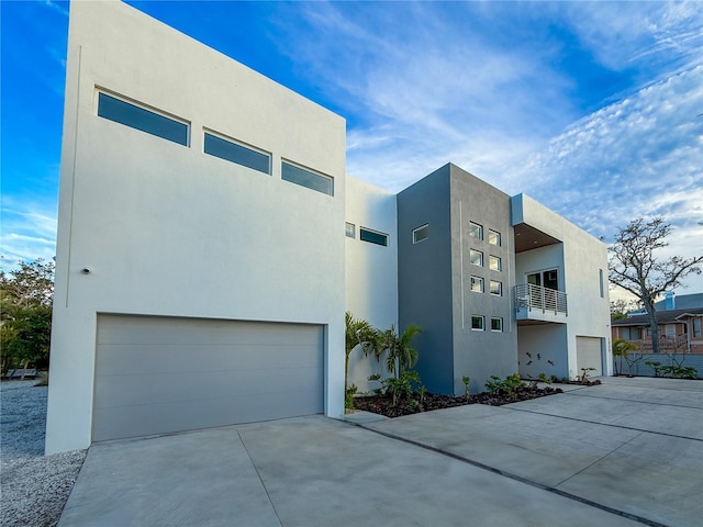 contemporary house featuring a garage, concrete driveway, and stucco siding