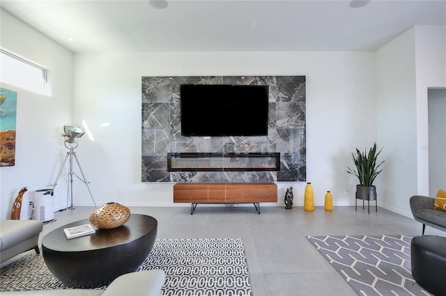 living area with a high end fireplace and baseboards