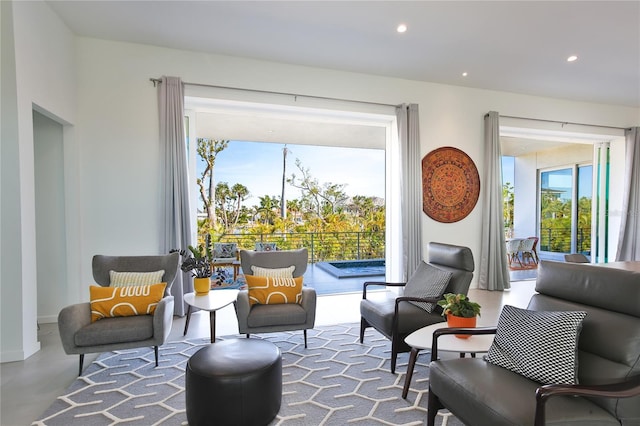 sitting room featuring finished concrete floors and recessed lighting