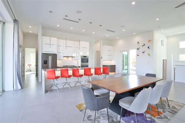 dining space with a high ceiling, visible vents, and recessed lighting