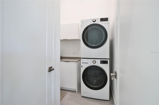 clothes washing area featuring stacked washer / drying machine