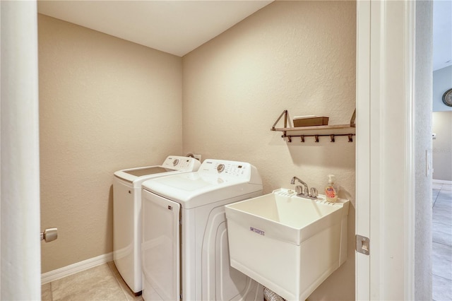 washroom featuring sink, washing machine and dryer, and light tile patterned flooring