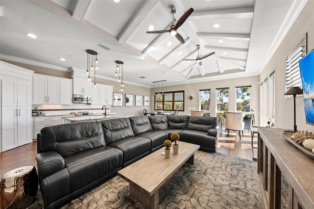 living room with dark wood-type flooring, lofted ceiling with beams, sink, crown molding, and ceiling fan