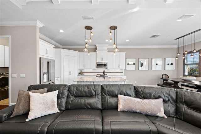 living room with ornamental molding, sink, and washer / clothes dryer