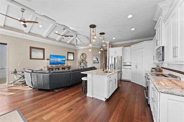 kitchen featuring pendant lighting, ceiling fan, an island with sink, appliances with stainless steel finishes, and white cabinetry