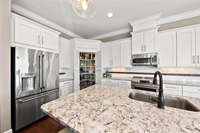 kitchen featuring light stone counters, white cabinetry, sink, and appliances with stainless steel finishes