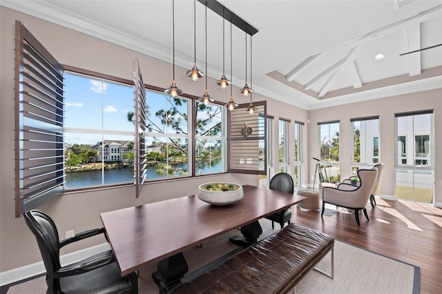 dining area with wood-type flooring, a water view, and crown molding