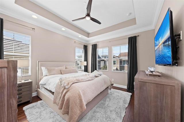 bedroom with a raised ceiling, ceiling fan, dark hardwood / wood-style flooring, and ornamental molding