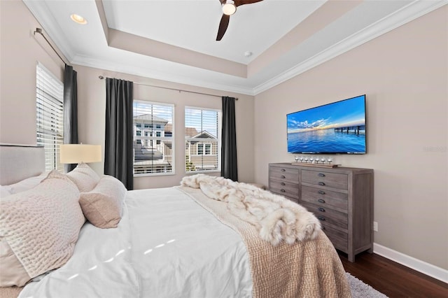 bedroom with a tray ceiling, ceiling fan, dark hardwood / wood-style flooring, and crown molding