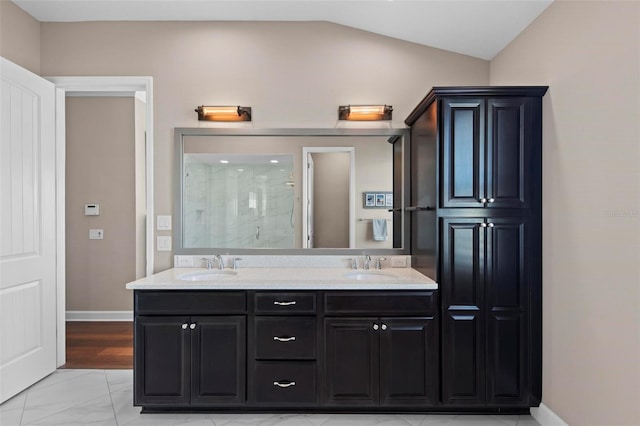 bathroom featuring vanity, vaulted ceiling, and a shower with shower door