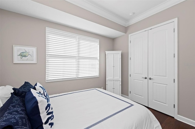 bedroom with dark hardwood / wood-style flooring, ornamental molding, and a closet