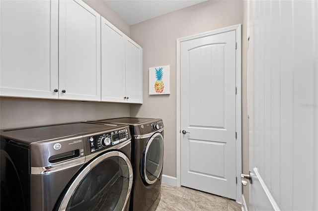 washroom with cabinets and washer and dryer