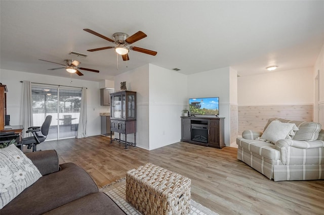 living room featuring light wood-type flooring and ceiling fan