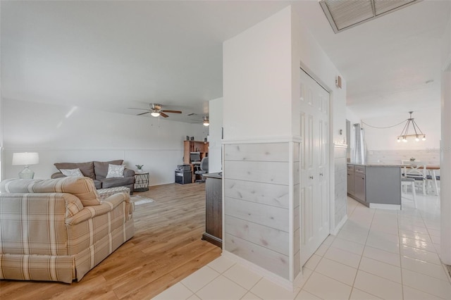 tiled living room with ceiling fan