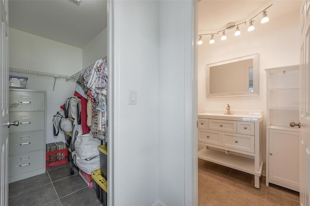 spacious closet featuring tile patterned floors and sink