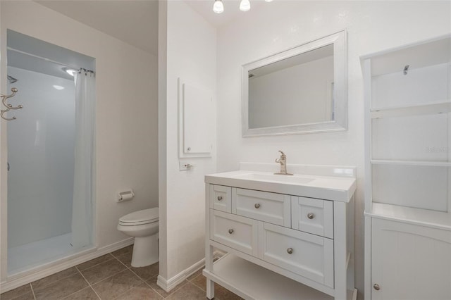 bathroom featuring a shower, vanity, toilet, and tile patterned flooring