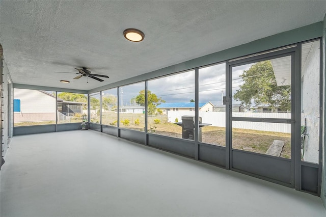 unfurnished sunroom with ceiling fan