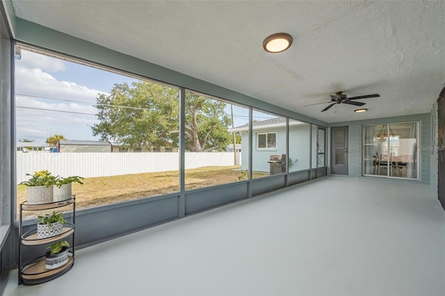 unfurnished sunroom with ceiling fan