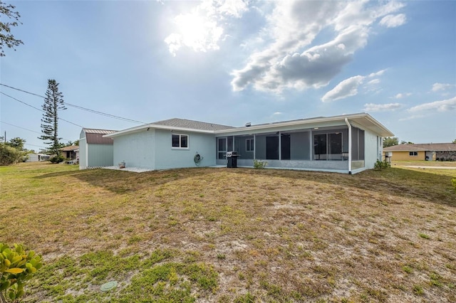 rear view of property with a sunroom and a yard