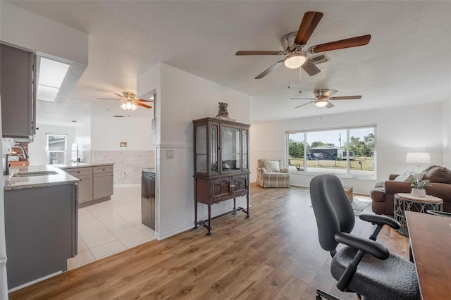 625 Ennis Ter NW, Port Charlotte, FL 33952 - interior space with a ceiling fan, a sink, and light wood finished floors