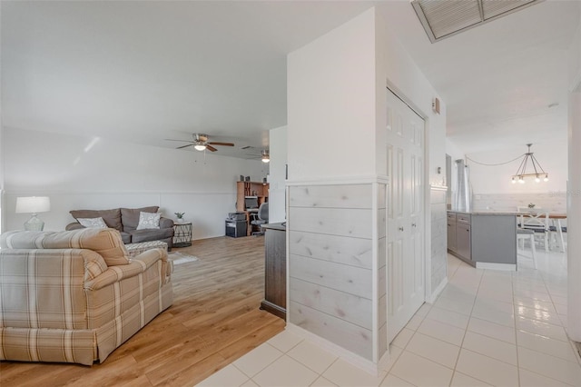 625 Ennis Ter NW, Port Charlotte, FL 33952 - living area featuring light tile patterned floors, ceiling fan with notable chandelier, and visible vents