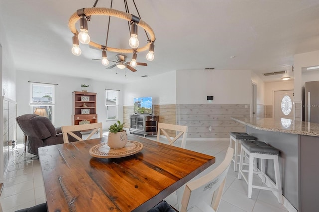 625 Ennis Ter NW, Port Charlotte, FL 33952 - dining space featuring wood walls, light tile patterned flooring, visible vents, a ceiling fan, and wainscoting