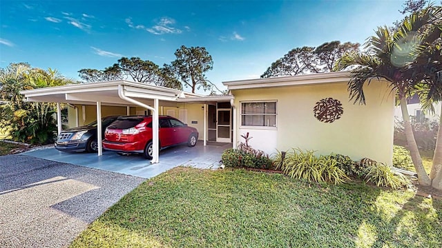 view of front of house with a front yard and a carport