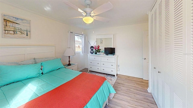 bedroom featuring a closet, hardwood / wood-style flooring, ceiling fan, and crown molding