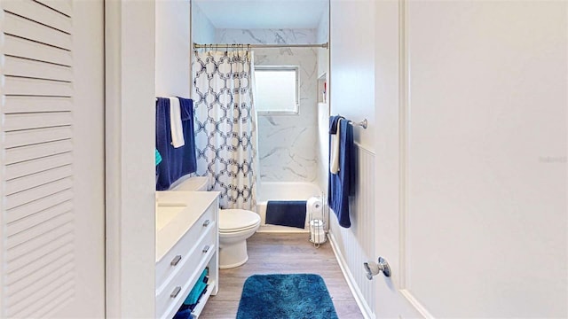 full bathroom with hardwood / wood-style floors, vanity, shower / tub combo, and toilet