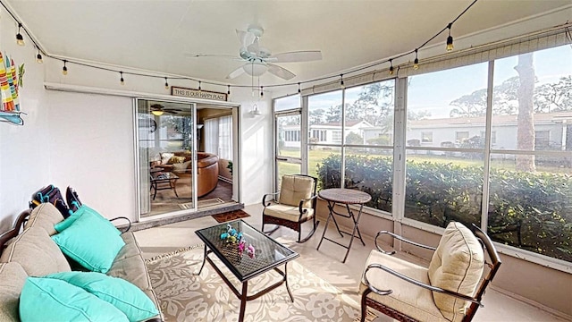 sunroom featuring ceiling fan and a mountain view