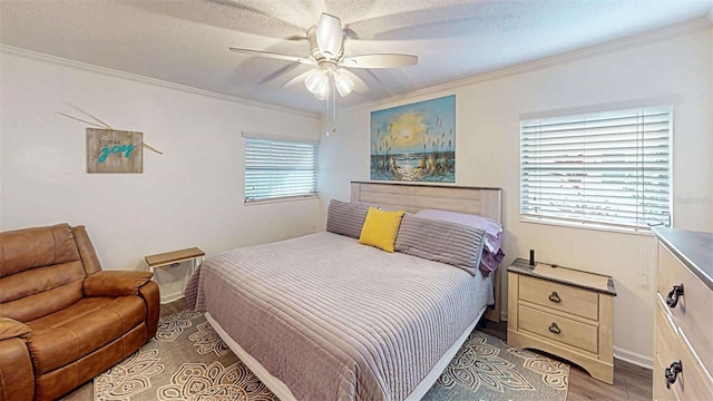 bedroom featuring light wood-type flooring, a textured ceiling, ceiling fan, and crown molding