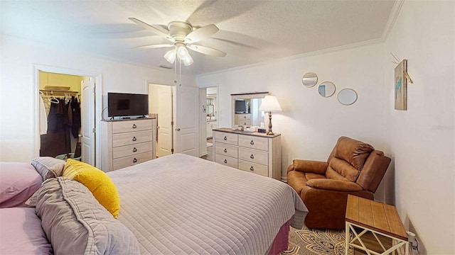 bedroom with a closet, a walk in closet, ceiling fan, and crown molding