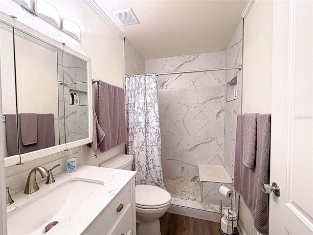 bathroom with walk in shower, crown molding, hardwood / wood-style floors, toilet, and vanity