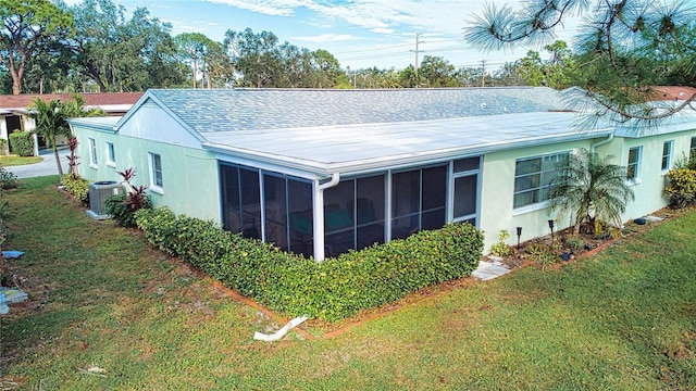 view of home's exterior with a lawn, a sunroom, and cooling unit