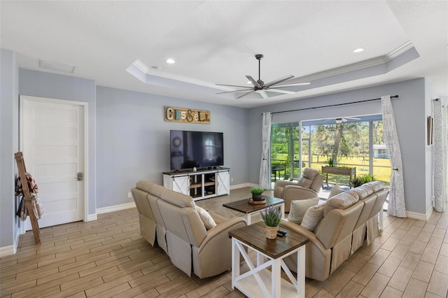 living room with ceiling fan, crown molding, and a tray ceiling