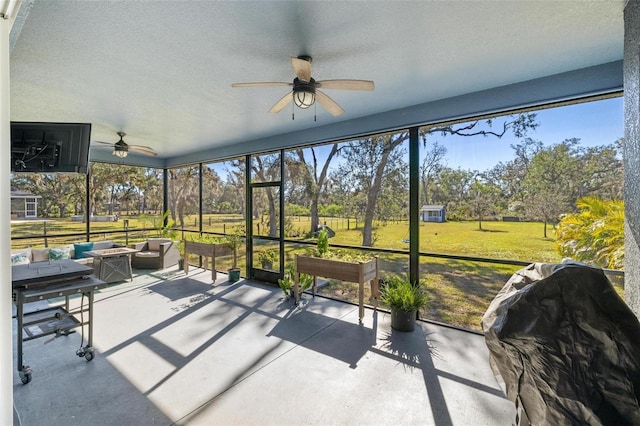 sunroom featuring ceiling fan