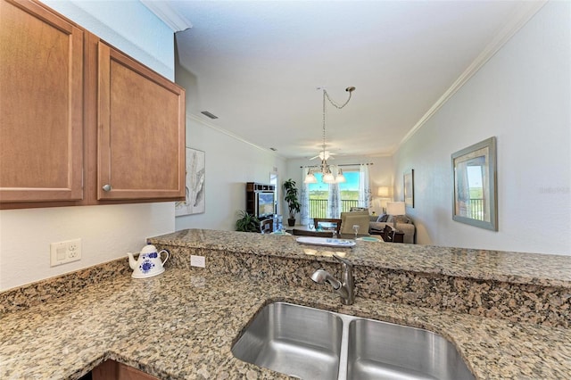 kitchen with crown molding, sink, ceiling fan, and stone countertops