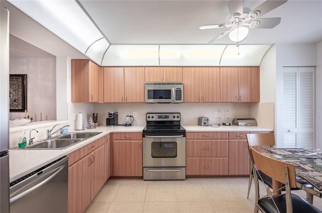 kitchen with light brown cabinetry, appliances with stainless steel finishes, light tile patterned floors, and sink