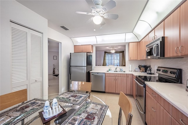 kitchen featuring stainless steel appliances, decorative backsplash, ceiling fan, light tile patterned flooring, and sink