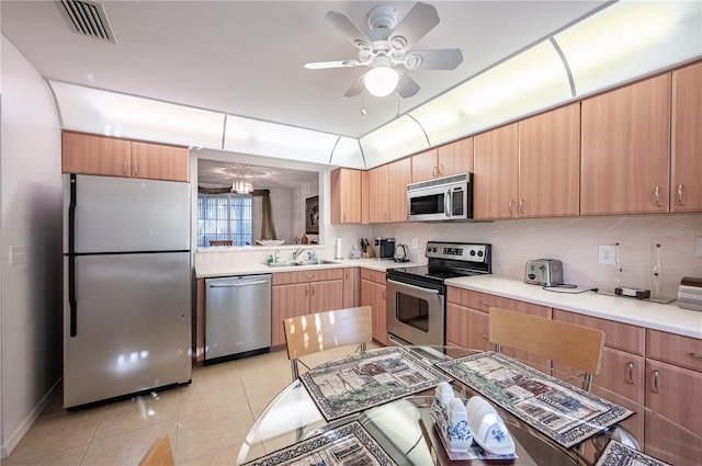 kitchen with stainless steel appliances, sink, ceiling fan, light tile patterned floors, and tasteful backsplash