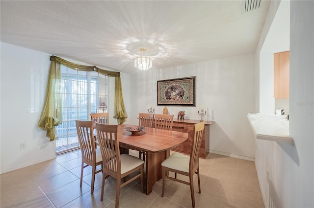 tiled dining room featuring an inviting chandelier and plenty of natural light