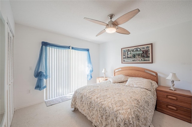 carpeted bedroom featuring a closet, ceiling fan, and a textured ceiling