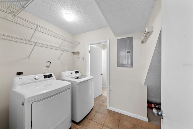 clothes washing area featuring washer and dryer, light tile patterned floors, a textured ceiling, and electric panel